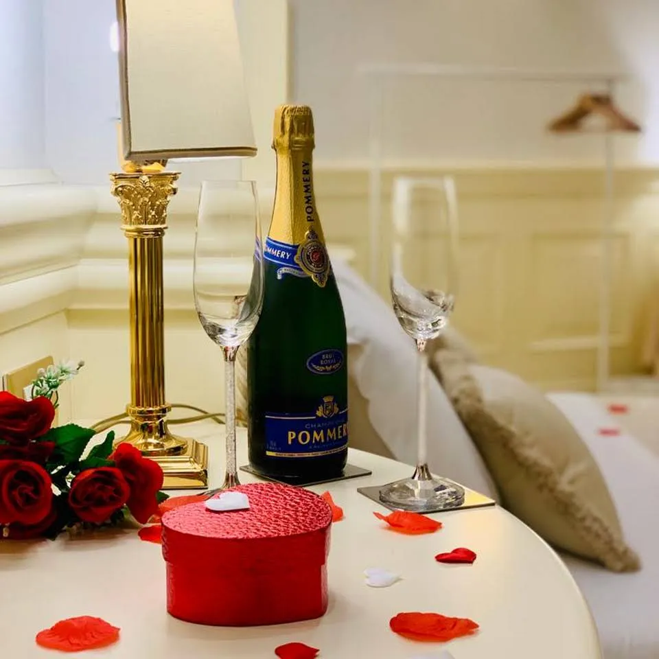 Romantic welcome set-up with sparkling wine and rose petals