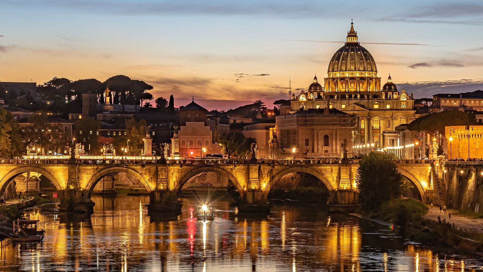 Rome at sunset: St. Peter's dome and the Tiber with a lit bridge